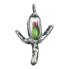 a silver pendant with a pink flower on it's center and green leaves in the middle