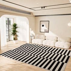 a living room with white furniture and black and white striped rugs on the floor