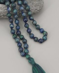 Harness the power of Azurite beads to gain clarity and personal wisdom during your meditative practice. Made of 108 beads, use a mala simply by moving through its beads one by one. Bead size: 6mm Individually Knotted between each bead Made of Azurite beads Blue/green shaded cotton tassel Bead Configuration: 108 Azurite beads + 1 Guru Bead Due to the nature of natural stones, this piece will feature exquisite variations in surface patterns and overall appearance. Such details enhance the unique b Buddha Groove, Surface Patterns, Mala Meditation, 108 Bead, Beaded Tassels, Blue Beads, How To Make Beads, Turquoise Bracelet, Natural Stones