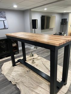 a kitchen island in the middle of a room with wood floors and black metal legs