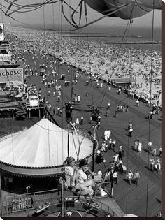 an aerial view of a carnival with people on the ground and in the water,