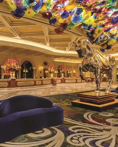 the lobby is decorated with many colorful glass sculptures and chandeliers hanging from the ceiling