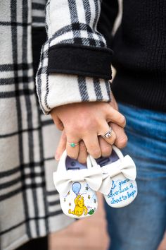 two people holding hands with winnie the pooh stickers on their thumb rings and ring bands