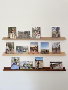 several photographs are arranged on wooden shelves in front of a white wall