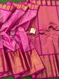 pink and gold colored saree laying on the ground