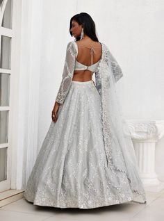 Enchant in this grey dupion silk embroidered lehenga featuring intricate mirror and zari detailing. Paired elegantly with a full-sleeve embroidered blouse and a tulle embroidered dupatta, this ensemble embodies grace and sophistication. Embroidered Organza Choli For Wedding, Fitted Sets With Sheer Dupatta For Ceremony, Fitted Bollywood Gown With Lace Work, Bollywood Style Fitted Gown With Lace Work, Fitted Bollywood Lace Gown, Wedding Set With Lace Work And Traditional Drape, Wedding Sets With Lace Work And Traditional Drape, Floor-length Fitted Lace Choli, Wedding Sets With Traditional Drape And Lace Work