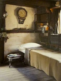 a room with a bed and a clock hanging on the wall next to a window