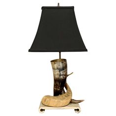 a lamp that is sitting on top of a wooden base with a black shade over it