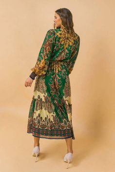 This is a beautiful brand new printed woven midi dress. It features a ruffled neckline with a tie/tassel. It has a peasant sleeve with smocked cuff, elasticized waist with sash tie, and ruffled hemline. It is made of 100% polyester, and the lining is also made of 100% polyester. Our model is 5'8" and wearing a size small. This item should be hand washed. Ships immediately to US addresses. Peasant Sleeve, Ruffled Neckline, Printed Midi Dress, New Print, Woven Fabric, High Neck Dress, Midi Dress, Long Sleeve Dress, Cuff