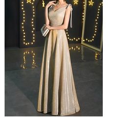 Gold V-neck Evening Dress With Sweep Train, Gold V-neck Holiday Evening Dress, Metallic Maxi Length Prom Dress, Gold V-neck Evening Dress For Holidays, Gold Maxi Dress For Party Season, Champagne Evening Dress With Sweep Train, Champagne Maxi Length Evening Dress, Elegant Sleeveless Gold Ball Gown, Gold Sleeveless Gown For Banquet