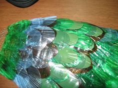 a pile of green plastic cups sitting on top of a wooden table