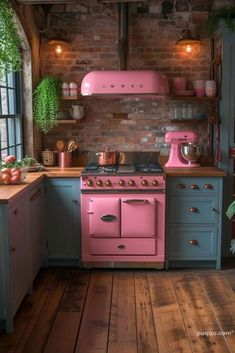 a pink stove top oven sitting inside of a kitchen next to a wooden countertop