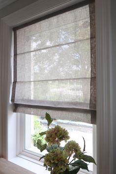 a vase filled with flowers sitting on top of a window sill next to a window