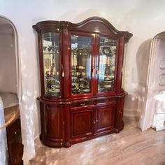 a large wooden china cabinet with glass doors