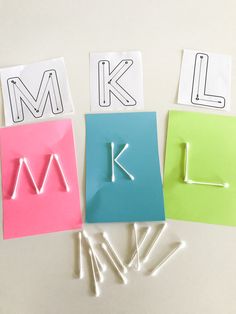 the letter k is made out of colored paper and pinned to magnets with clothes pins