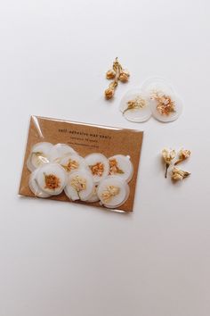 several pieces of food sitting on top of a white table next to buttons and flowers