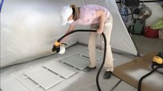 a woman is using a vacuum to clean the floor