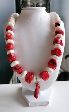 Handmade red/white coral necklace with pendant. The length of the two-tone chain is approx. 54 cm plus an extension chain. The statement necklace is made from natural coral beads in irregular shape in red (12 mm - 27 mm), white hexagonal coral beads (15 mm x 7 mm) and white coral beads in discus shape (13 mm x 7 mm). The length of the chain pendant made of coral branch is approx. 30 mm. Between the white hexagonal beads there are red branch coral beads (5 mm - 8 mm). S-clasps, pearl caps and the Red Coral Pendant Necklace, Red Pendant Necklace With Lobster Clasp, Unique White Shell Pendant Necklace, Coral Necklace With Lobster Clasp As Gift, Red Coral Pendant Necklace As Gift, Red Coral Pendant Necklace For Gift, Unique White Pendant Shell Necklace, Red Coral Necklace With Lobster Clasp For Gift, Red Coral Necklace With Lobster Clasp As Gift