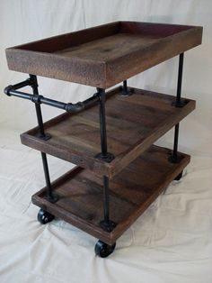 three tiered wooden cart with metal wheels