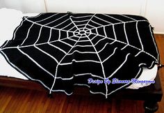 a bed with a spider web blanket on it