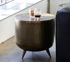 a table with two glasses on it next to a couch