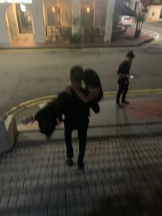 two people hugging each other while walking down the street with their dog in front of them