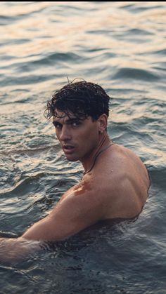 a shirtless man swimming in the water