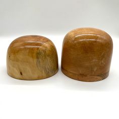 two wooden objects sitting side by side on a white surface