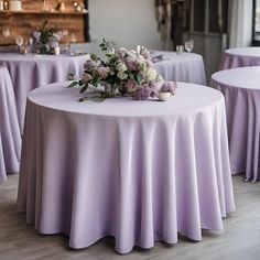 the table is covered with lavender colored linens