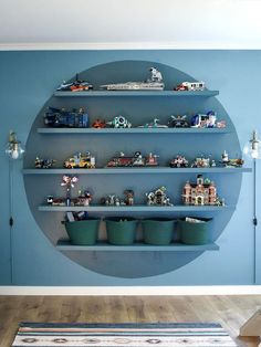 a blue wall with shelves filled with toys and figurines on top of them