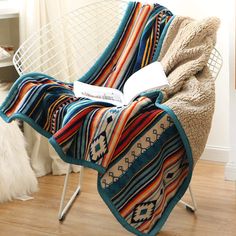 a chair with a blanket on top of it in front of a window next to a rug