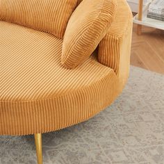 an orange corded couch with gold legs