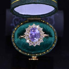 an amethoraite and diamond ring in a green velvet box with gold trimming