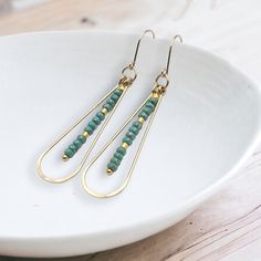 Adorn yourself with opulence and grace with the captivating Harley earrings. Made from gleaming gold, these long teardrop earrings are adorned with delicate turquoise seed beads, adding a touch of exotic charm to your look. Elevate any outfit with these luxurious and alluring earrings. Approximately 2.25” long Made with 14k Gold Filled Turquoise Seed Beads Polished to a high shine Handmade in Montana Sent in a ribboned gift box with polishing cloth African Turquoise, Jewelry Packaging, Teardrop Earrings, Christmas Shopping, Montana, Seed Beads, Gold Filled, Craft Ideas, Gift Box