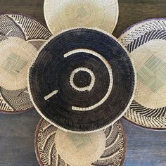 three woven baskets sitting on top of a wooden table next to an orange and black object