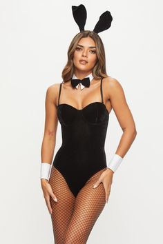 a woman wearing a bunny costume and fishnet stockings with her hands on her hips