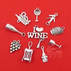 a bunch of charms that are on a red surface with the word wine written in it