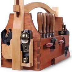 a wooden tool holder with many tools in it's compartments and an assortment of knives