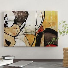 an abstract painting hangs on the wall above a desk with a laptop and phone next to it