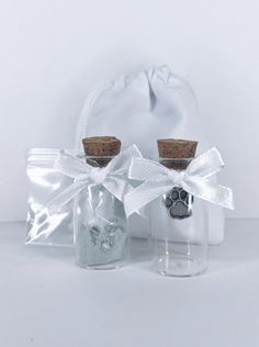 two glass bottles with corks in them and a white bag on the side that has a dog's paw printed on it