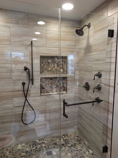 a walk in shower sitting next to a tiled wall and floor with two faucets