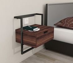 a nightstand with a book on it next to a bed