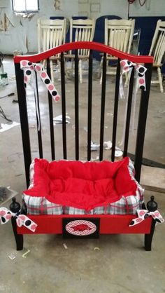 a red and black chair that has been made to look like a baby crib