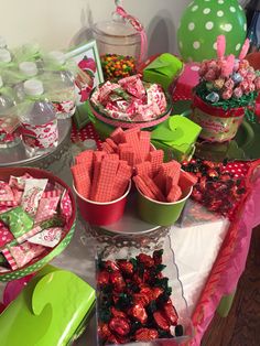 a table topped with lots of candy and candies on top of it's trays