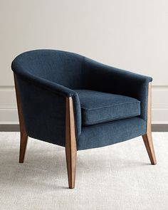 a blue chair sitting on top of a white rug