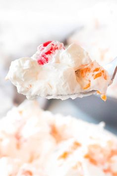 a spoon full of whipped cream and orange zest on top of it with a bite taken out