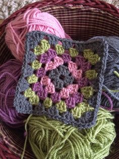 several crocheted items in a basket on the floor