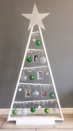 a white christmas tree with green ornaments on it