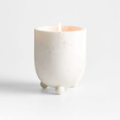 a candle that is sitting in a white cup