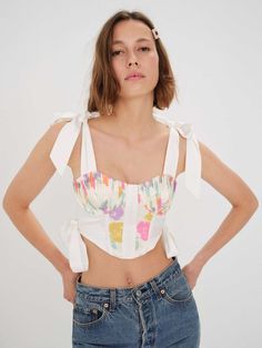 For Love and BOWS! This bow-ified bustier is an all-time statement! Show off your eye for style in the Eugene Bustier Top which snatches and shapes you in all the right places. It's unique ruching and ornate detailing makes it a true stand out. Pair it with any high rise jeans or skirt! Composition and Fit Tossed floral taffeta Pintucked cups Contrast panels Wide shoulder straps Oversized bows Hook and eye back closure Fully lined Fitted Summer Crop Top With Bow, Fitted Bow Crop Top For Summer, Summer Fitted Crop Top With Bow, Spring Bandeau Corset With Boned Bodice, Bandeau Corset With Boned Bodice For Spring, Summer Boned Bodice, Spring Feminine Corset With Straps, Spring Party Corset With Tie Back, Party Corset With Tie Straps